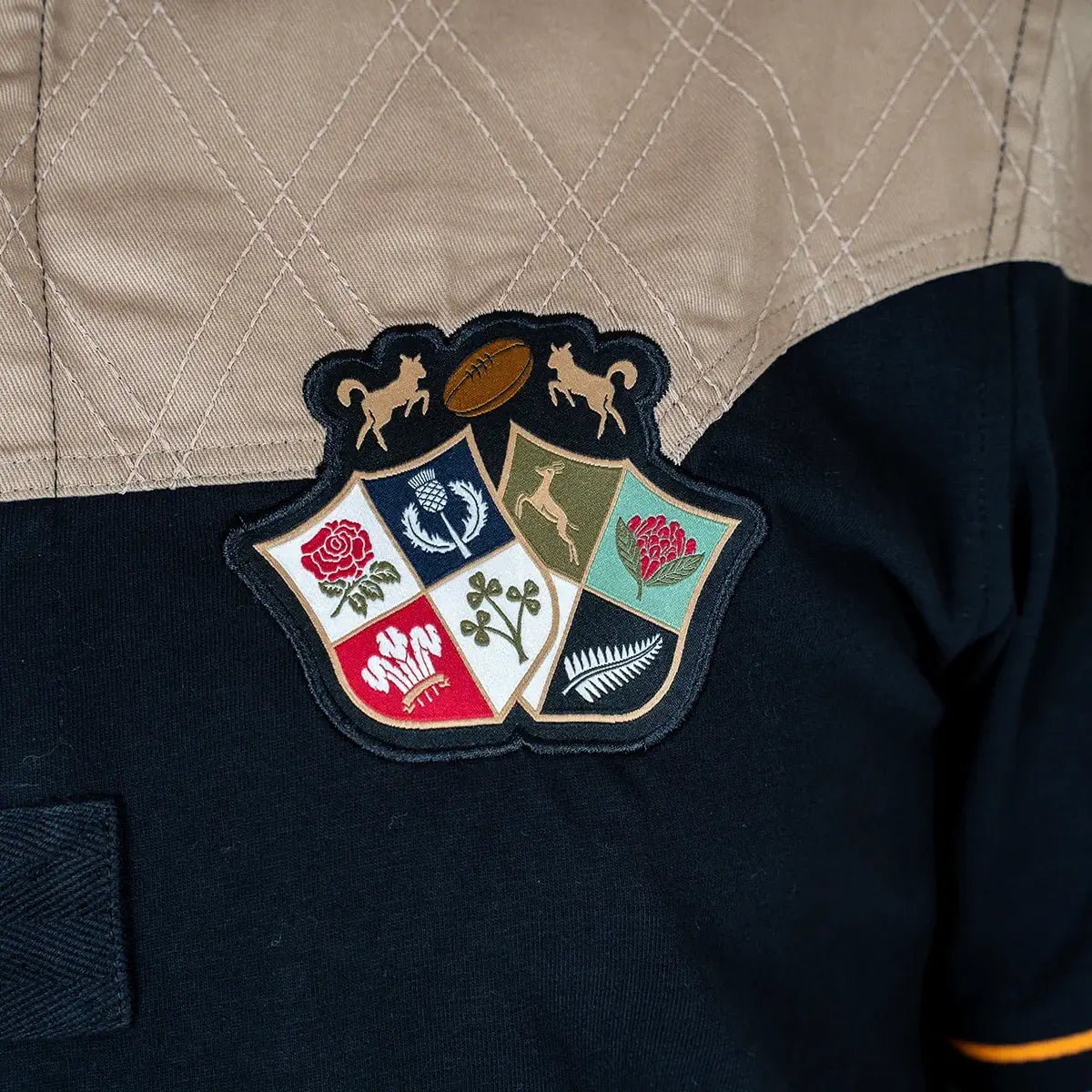 Polo scapulaire beige et noir Barbarians BACK to LEGEND (zoom blason poitrine)